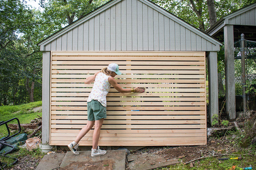 A person adding a wood frame to the opening of a garage