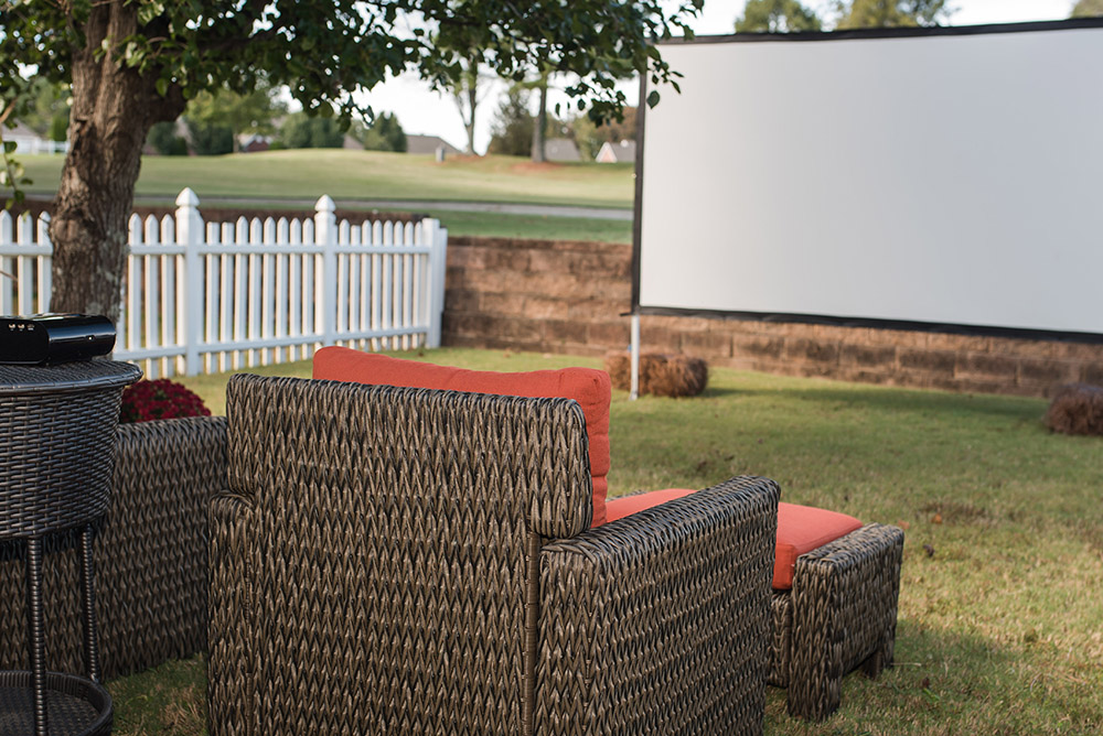 A backyard with outdoor seating and a projector screen.