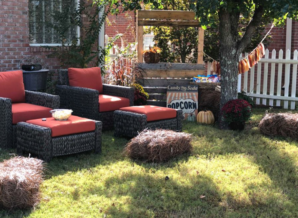 A backyard area set up for movie night with seating and popcorn.