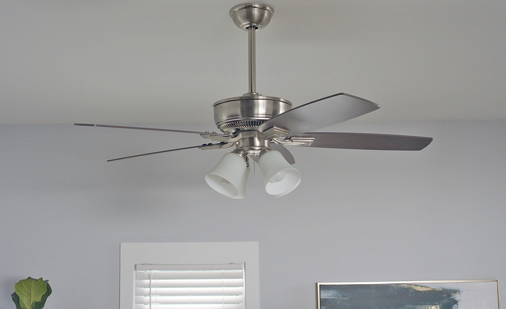 A ceiling fan hanging in a white room.