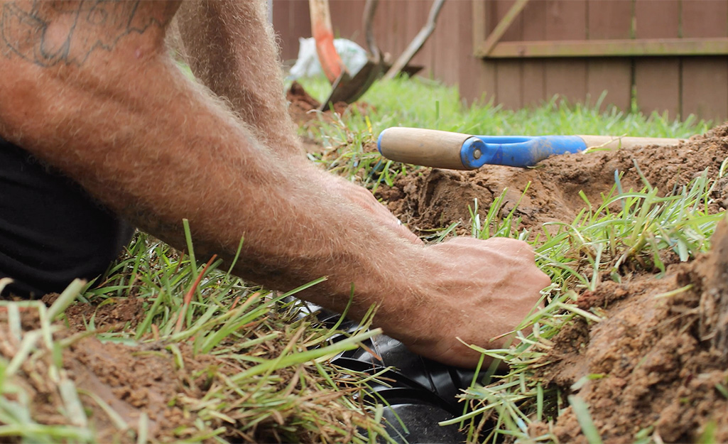 A person connecting French drain piping.