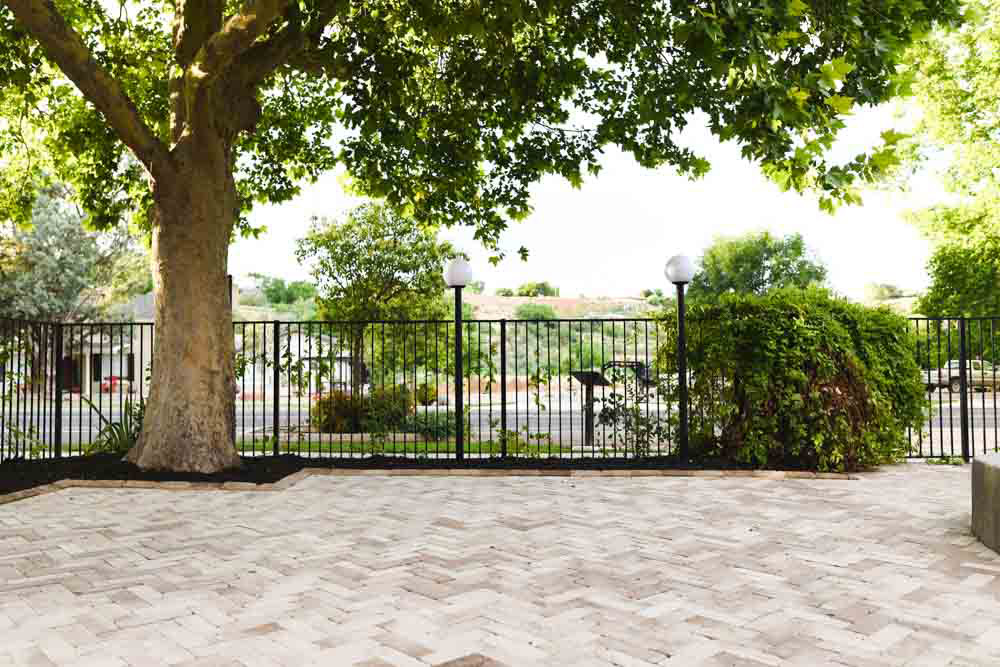 The after of an outdoor area with a herringbone paver patio.