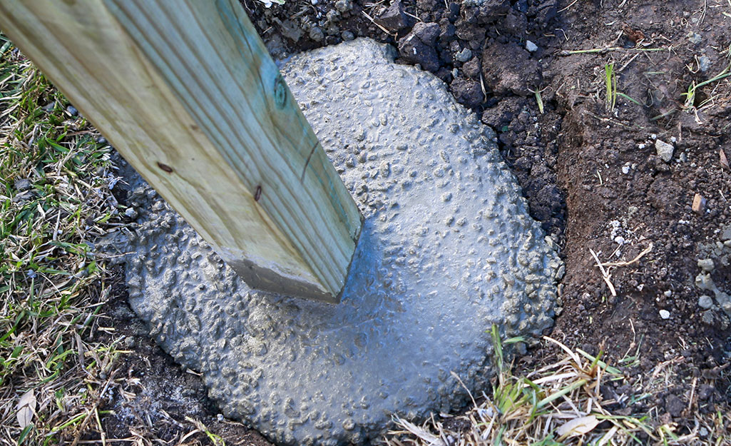 A mailbox post in hardening concrete.