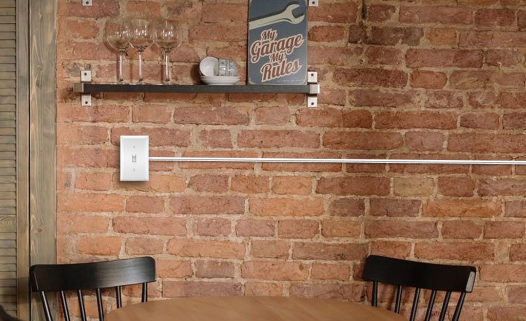 An electric outlet and raceway installed on a brick wall.