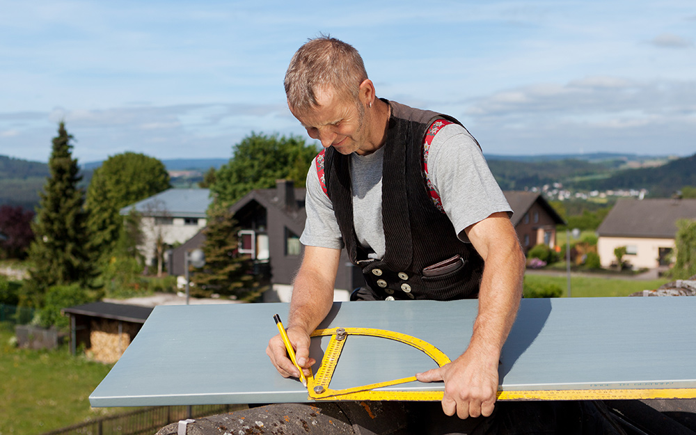 A man taking measurements of a roof. A man taking measurements of a roof.