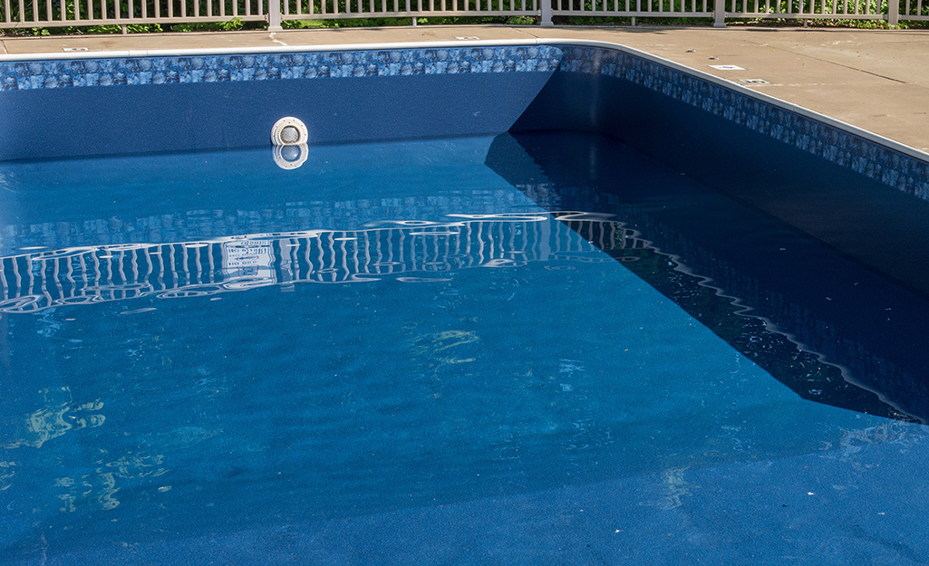 A close up of the inside of an in-ground pool in a backyard.