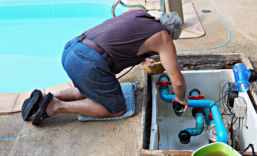 A man adds new fittings while replacing a pool pump.