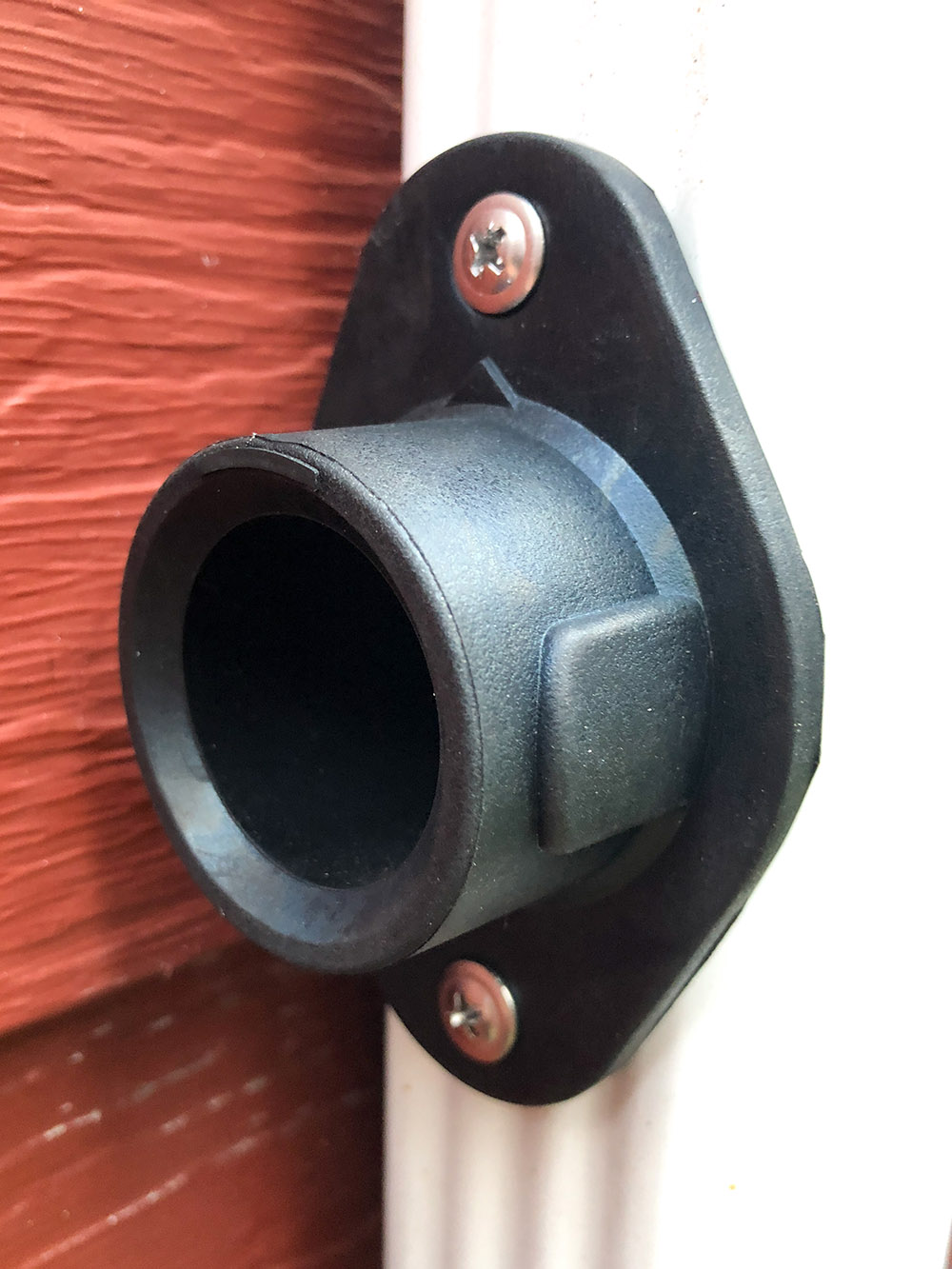 A diverter installed into a white downspout.