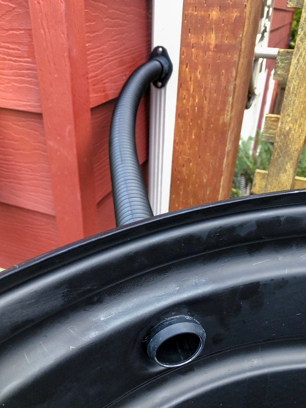 A flexible hose connects the diverter to the rain barrel.