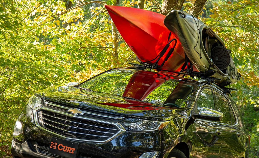 A vehicle with two kayaks strapped to a roof rack.