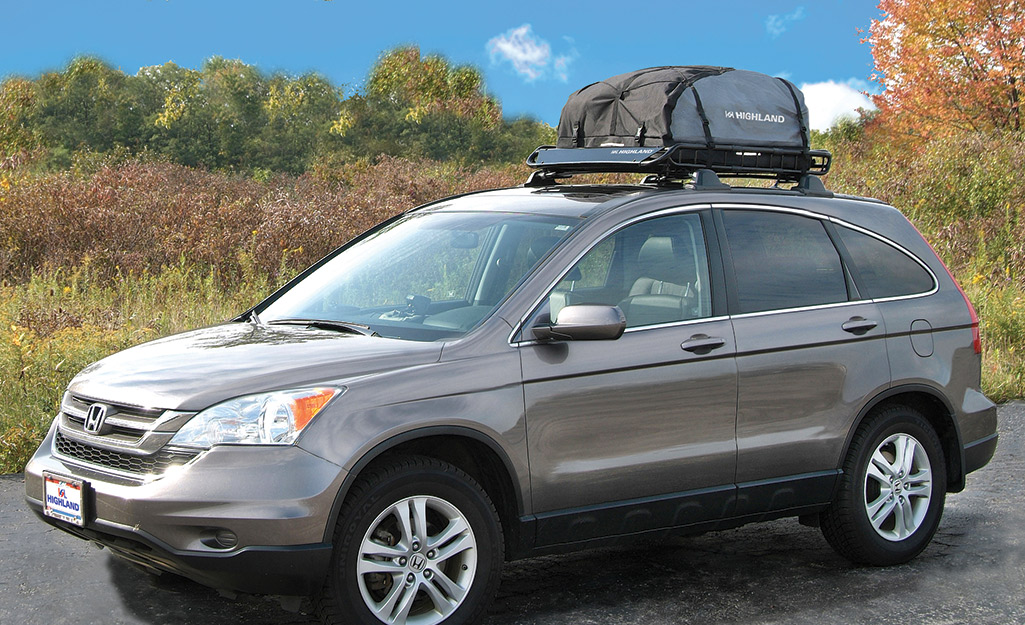 A cargo rack rests atop an SUV with raised rails on its roof.
