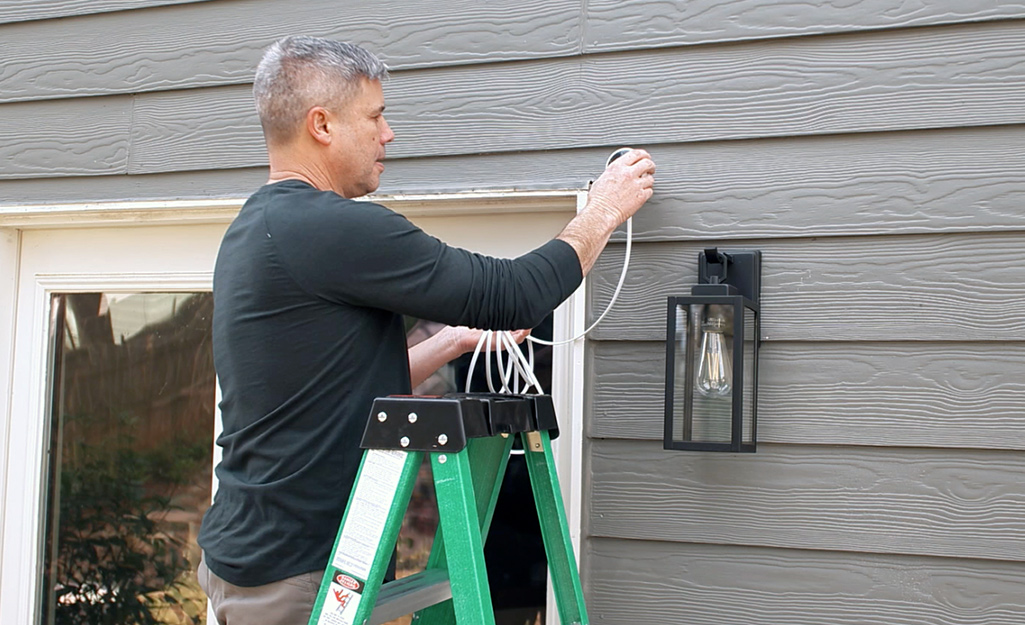 A person adjusting the angle of a security camera.