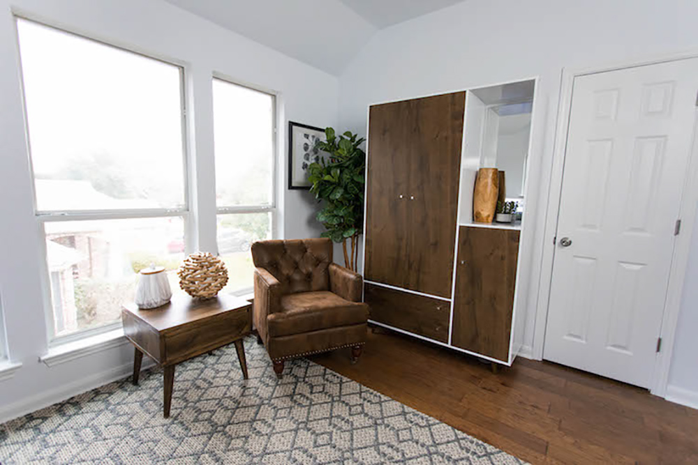 A decorated room with a chair and side table