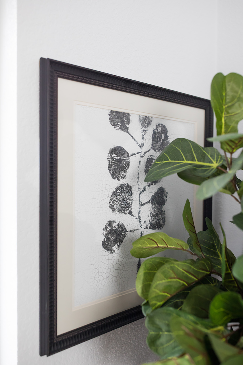 A framed art behind a green plant