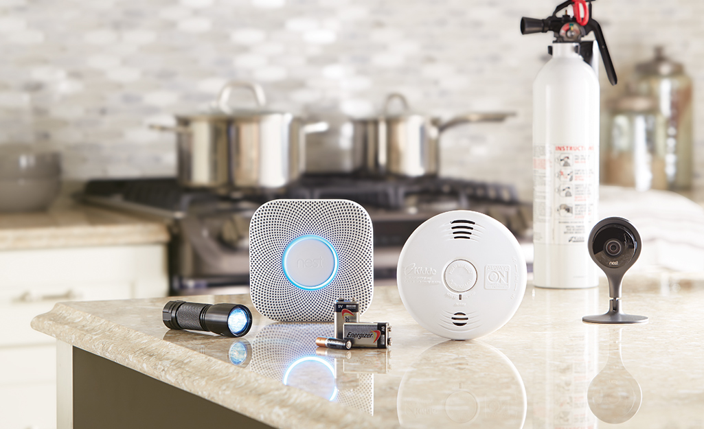 Several types of smoke alarms displayed on a kitchen counter.