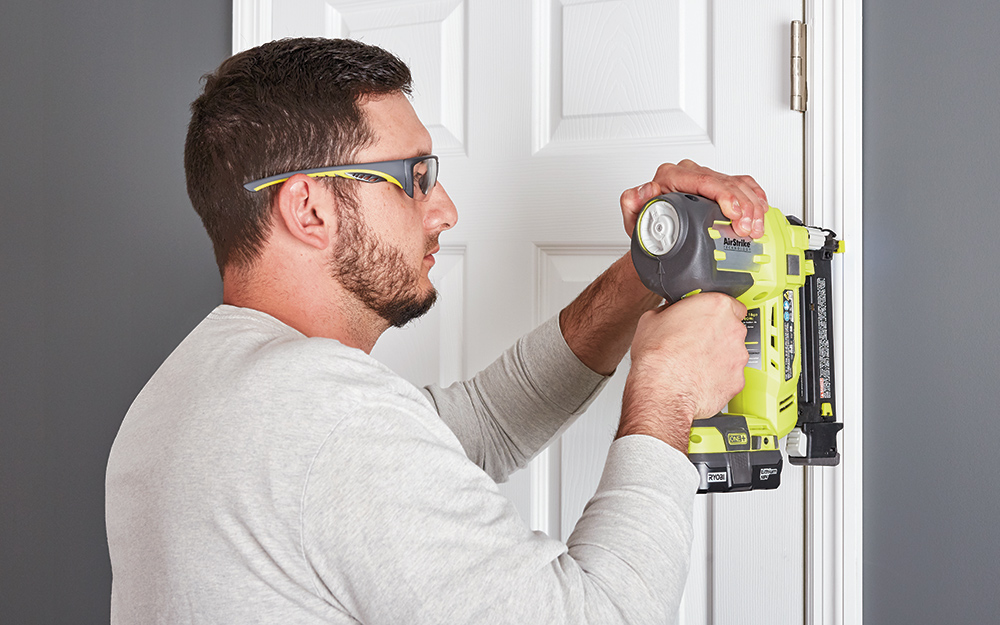 A man securing a white door into place. A man securing a white door into place.