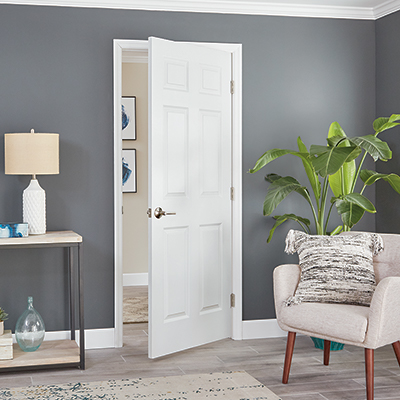 A white split-jamb door inside a home with grey walls.
