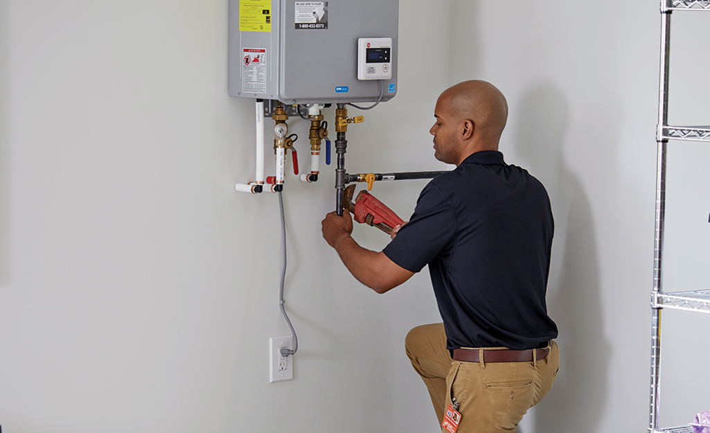Person installs water line on tankless water heater