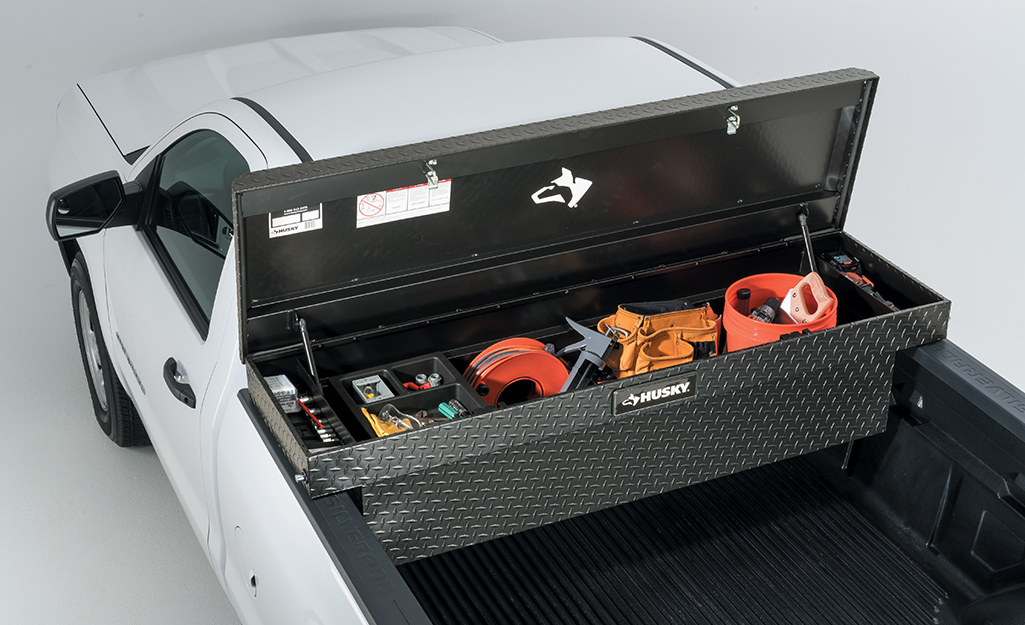 The lid of a truck tool box stands open to show neatly organized tools.