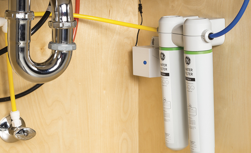 A water filter system installed under a kitchen sink.