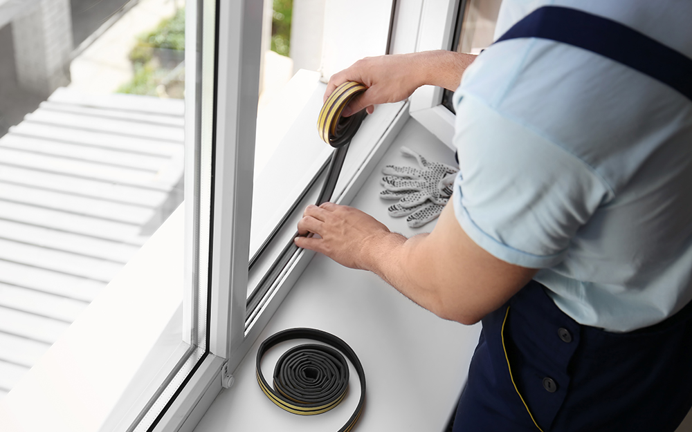 Man adds insulation to the window. Man adds insulation to the window.