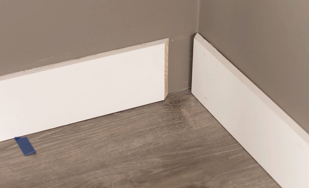 Two pieces of baseboard are added to the corner of a room.