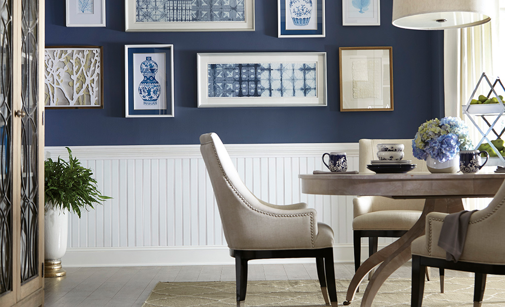 White beadboard wainscoting covers the lower half of a wall in a blue-and-white dining room