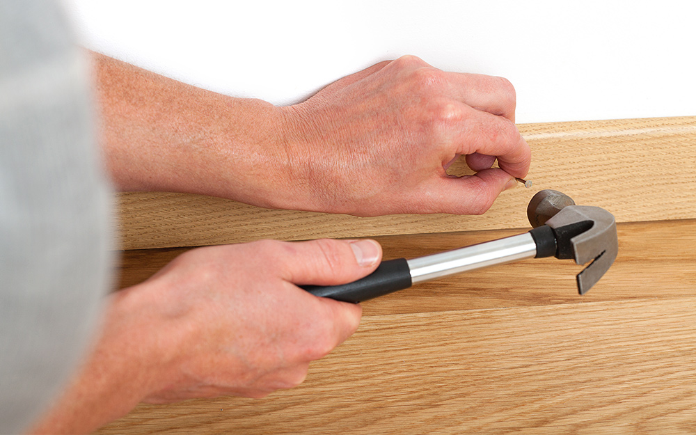 Person nails the boards in place. Person nails the boards in place.