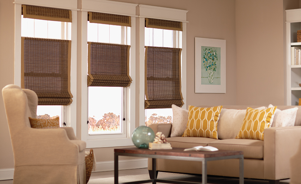 Woven shades on windows in a living room space.