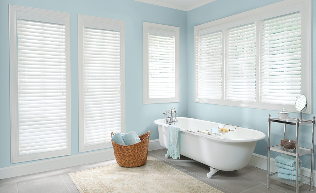 Faux wood blinds on windows in a bathroom.