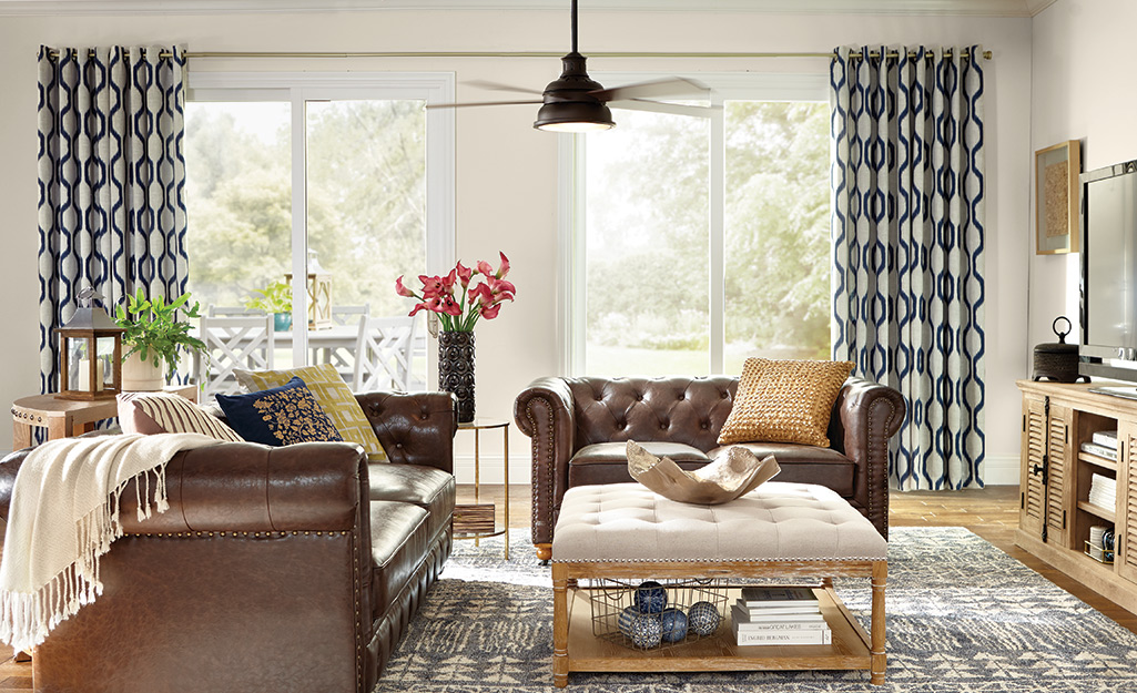 Drapery panels hanging above a window in a living space.