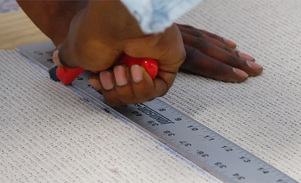 A person cutting carpet to prepare for installation. A person cutting carpet to prepare for installation.
