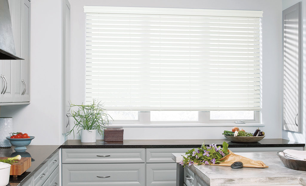 New faux wood blinds hang inside of a kitchen.