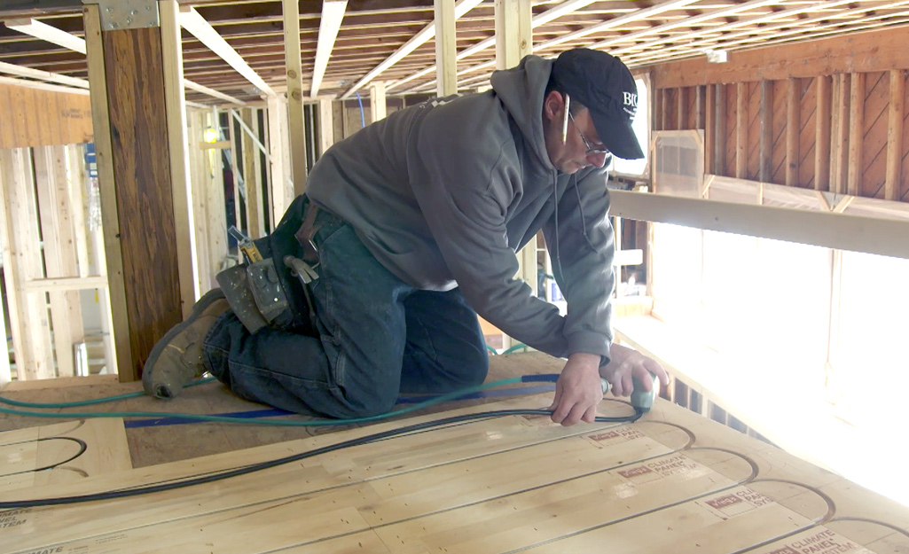 A person installing tubing for radiant floors.