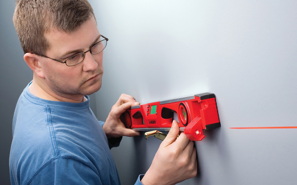A level being used to mark the location for the bottom of wall cabinets A level being used to mark the location for the bottom of wall cabinets