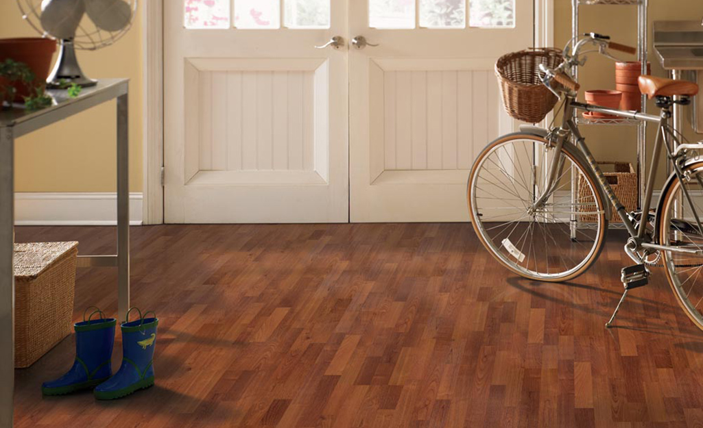 A bicycle sits in a row with laminate flooring.