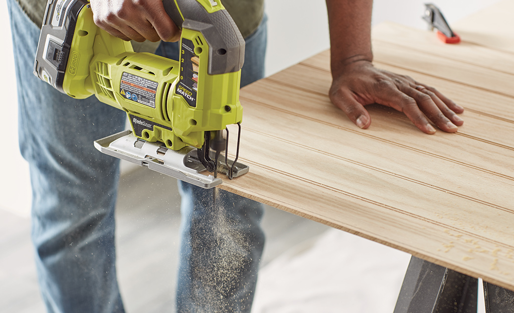 Someone cutting a sheet of paneling