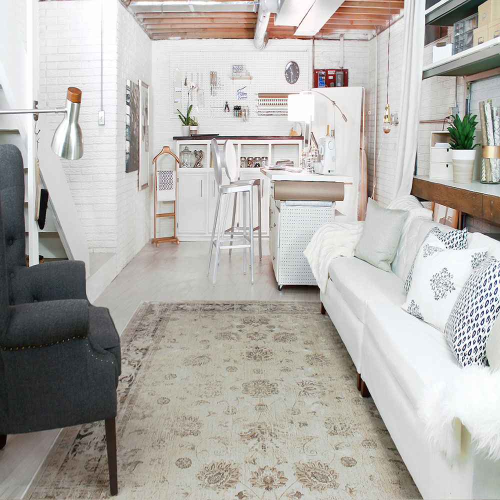 A basement decorated with a rug and furniture.