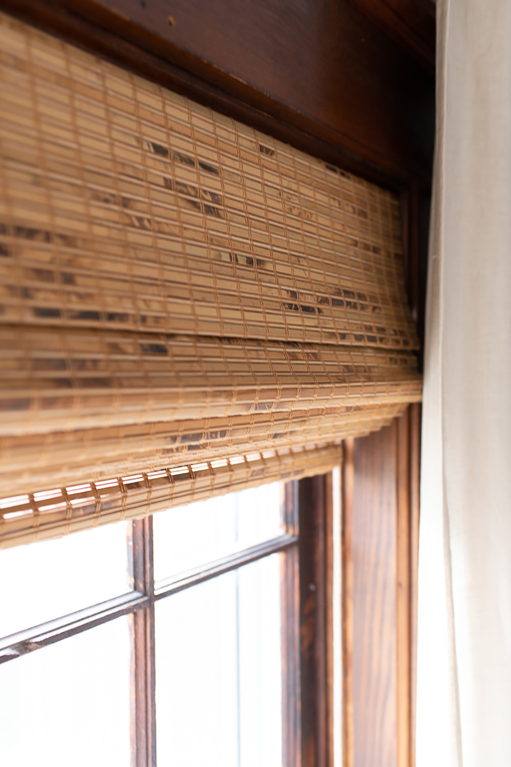 A window with horizontal natural woven roman shades.