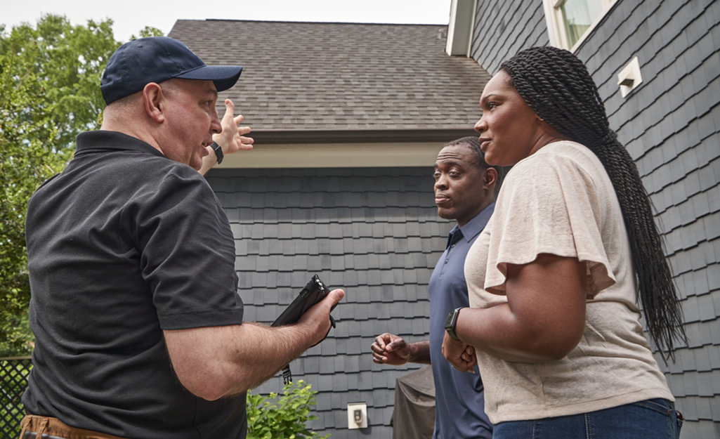 Man talks to a couple about their roof. 