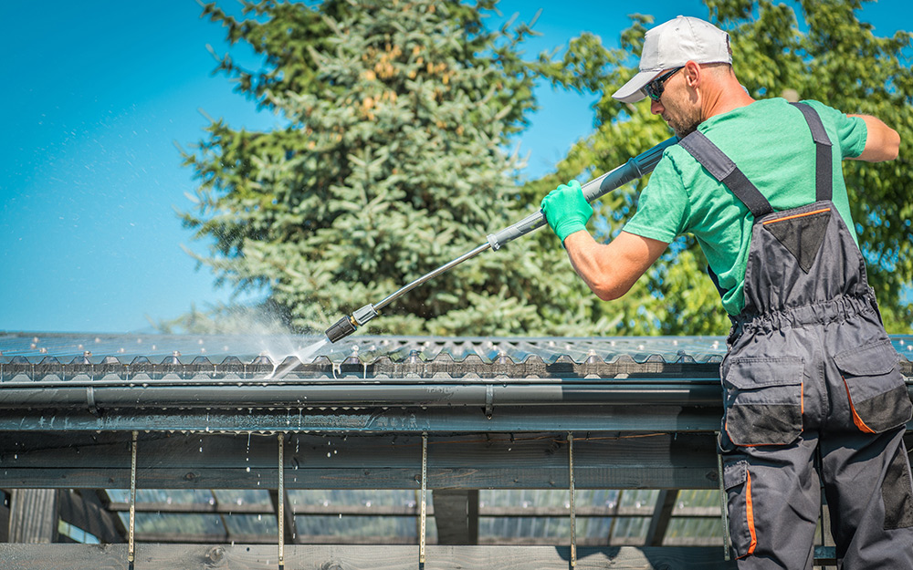 Man preps and cleans a roof. Man preps and cleans a roof.