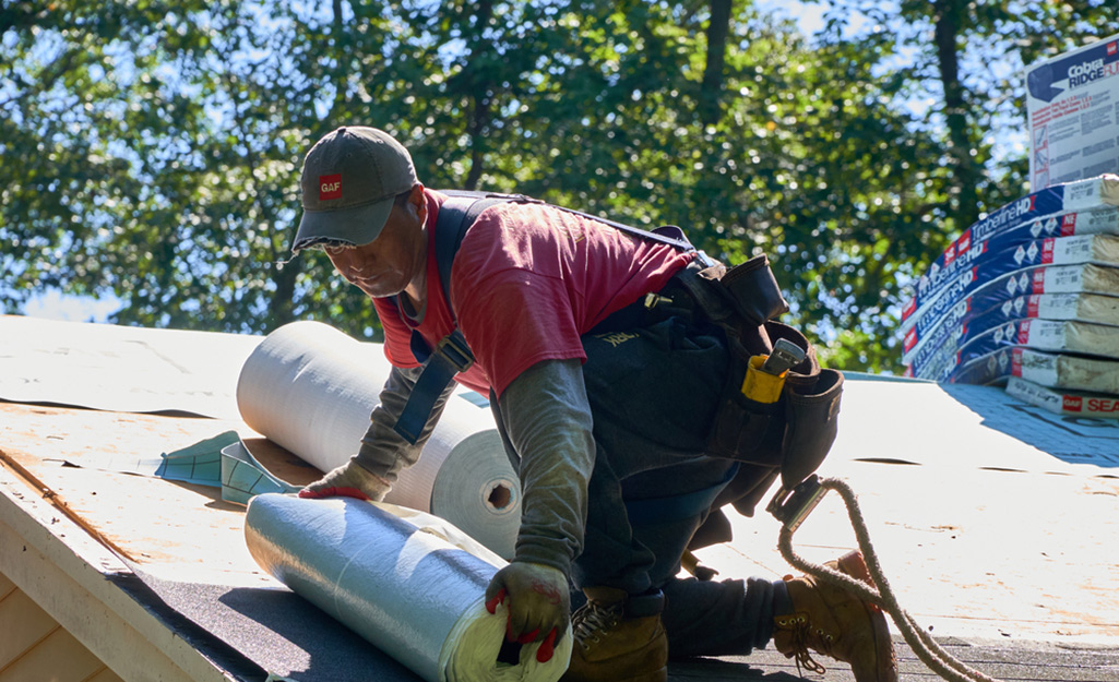 Person prepping the roof for shingles installation.