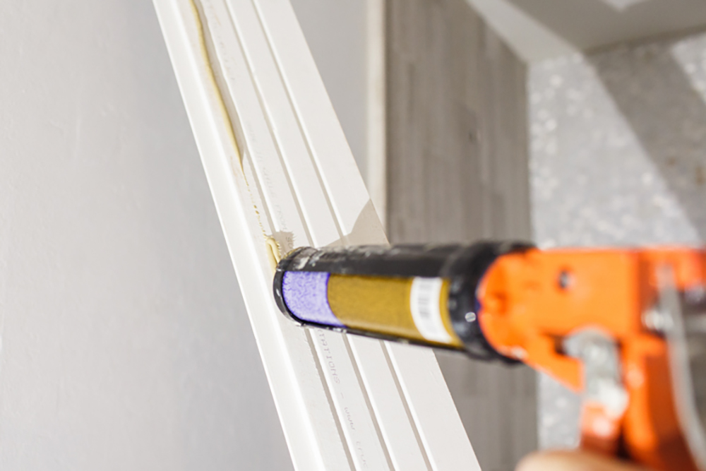 Construction adhesive is added to the backside of a shiplap board.