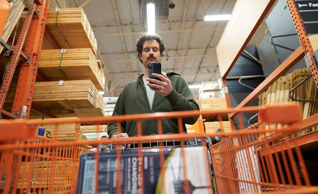 A person using their phone to find doors in The Home Depot.