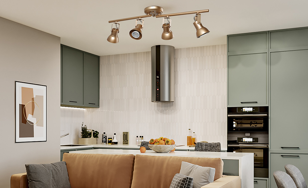 A copper track lighting fixture hangs from the ceiling of a kitchen.