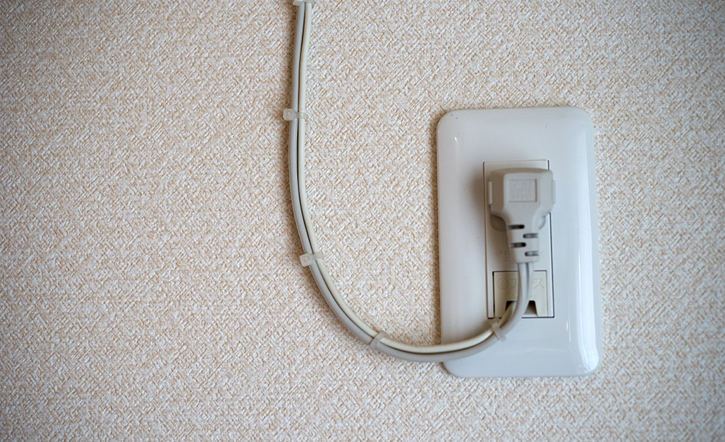 An electrical cord stapled in place to secure it.