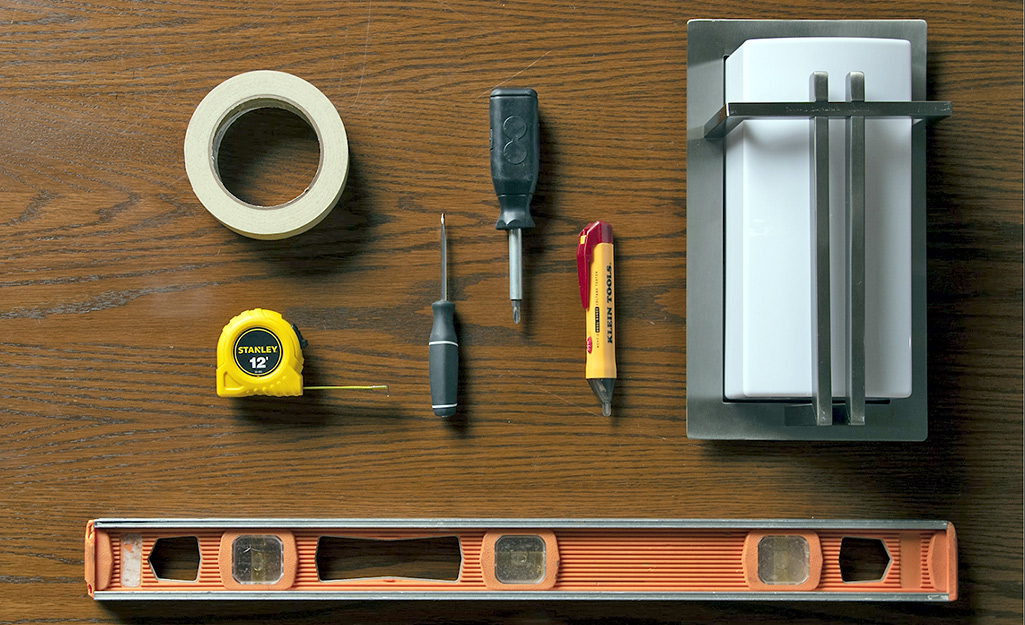 A tape measure, level and other tools laid out on a table.