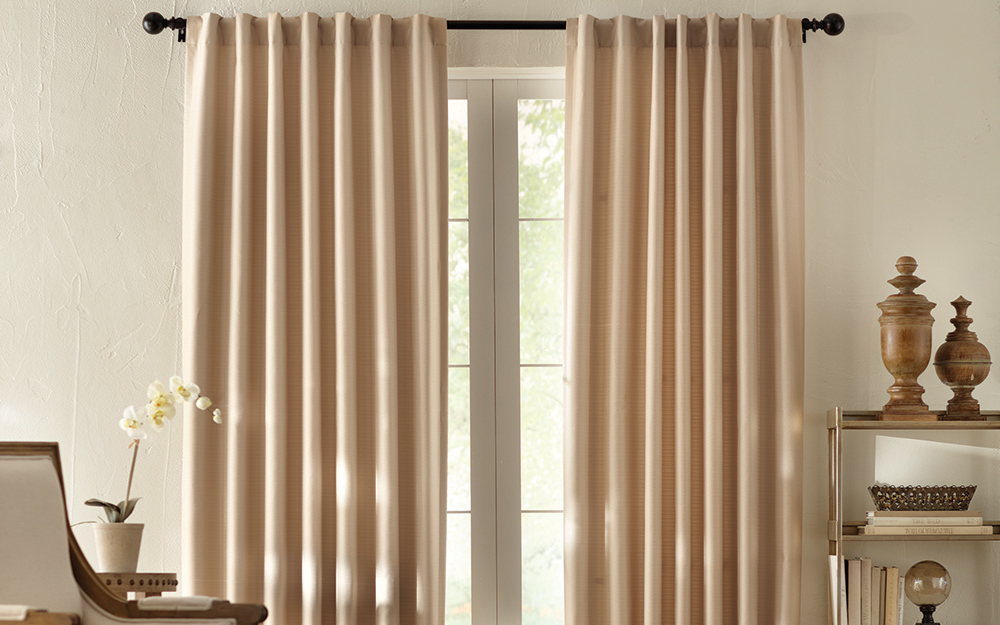Long thermal window curtains hanging in a room.
