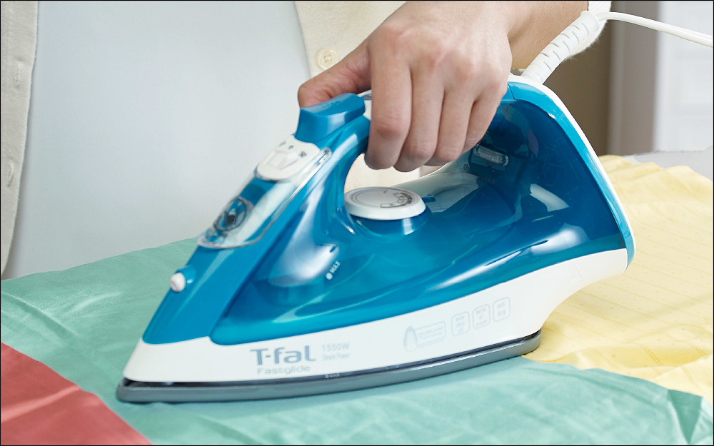 A person ironing fabric.