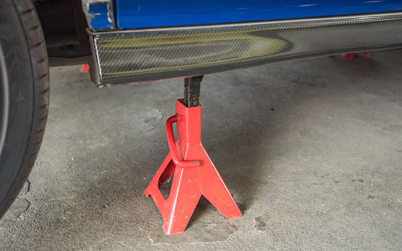 A jack stand supporting a car.